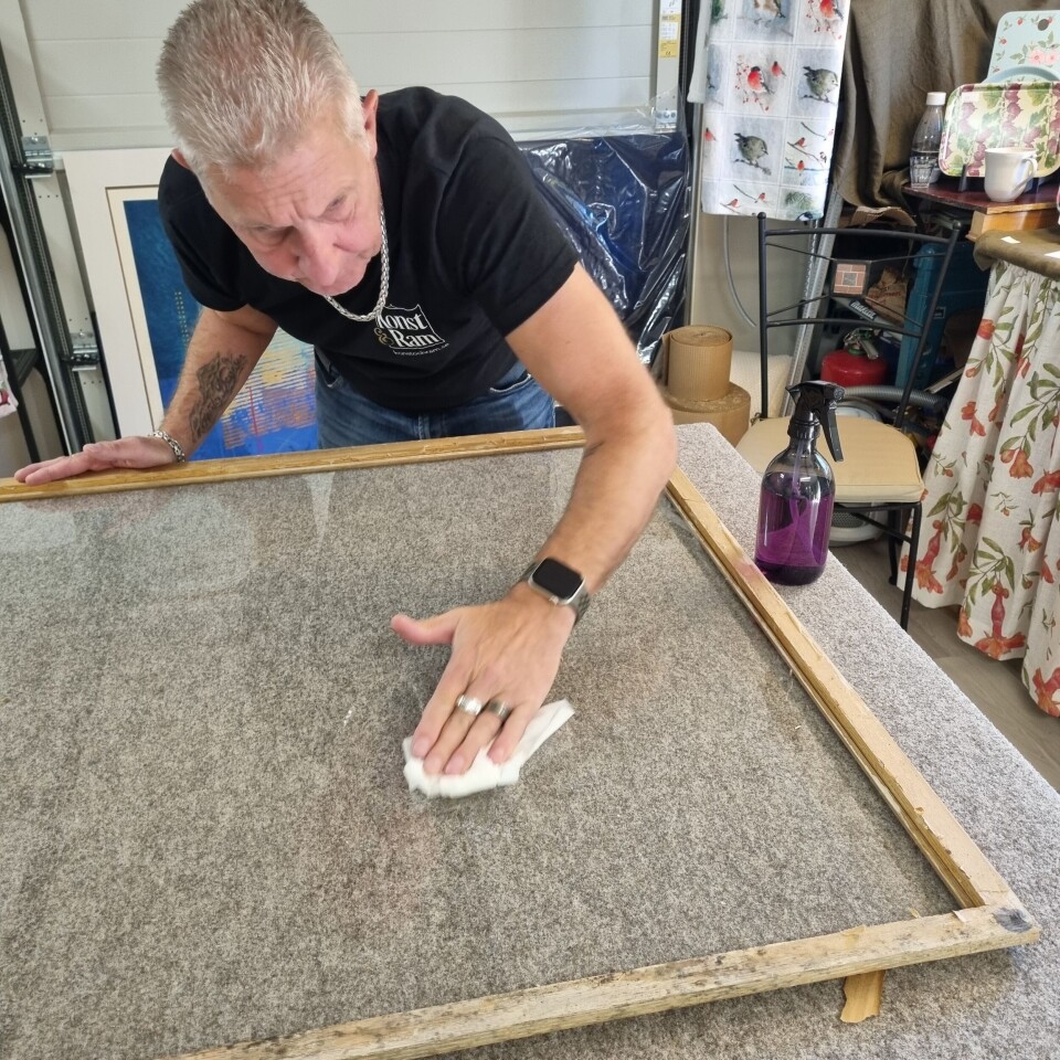 Mats Enarsson arbetar på en glasinramning.