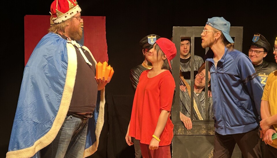 Zomnias Kung (Christoffer Andersson) styrs av den onda kristallen och ifrågasätts och motarbetas av några ungdomar (Anne Arelind i röd keps och Max Kinnbo i blå keps).